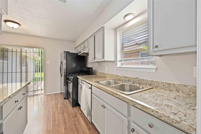 11750 Murr Way, Houston, TX 77048 - kitchen featuring dishwasher, a sink, gas range oven, light countertops, and light wood-style flooring