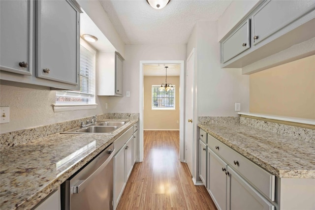 11750 Murr Way, Houston, TX 77048 - kitchen with dishwasher, a sink, light wood-style floors, a textured ceiling, and baseboards