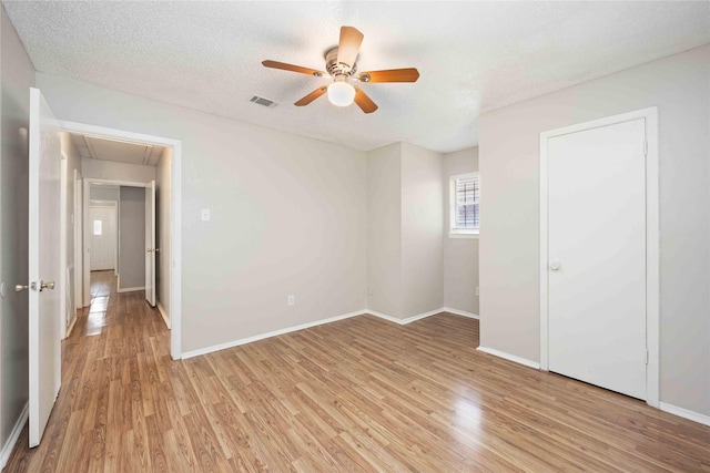 11750 Murr Way, Houston, TX 77048 - unfurnished bedroom featuring attic access, light wood-style flooring, baseboards, ceiling fan, and a textured ceiling