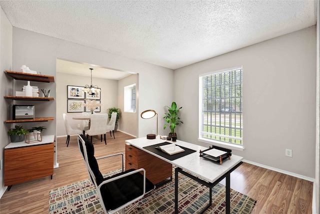 11750 Murr Way, Houston, TX 77048 - home office with light wood-style floors, a chandelier, a textured ceiling, and baseboards