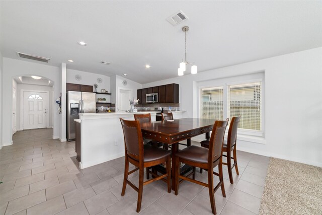 6815 Bardsdale Ct, Rosharon, TX 77583 - dining area with light tile patterned floors, arched walkways, a chandelier, recessed lighting, and baseboards