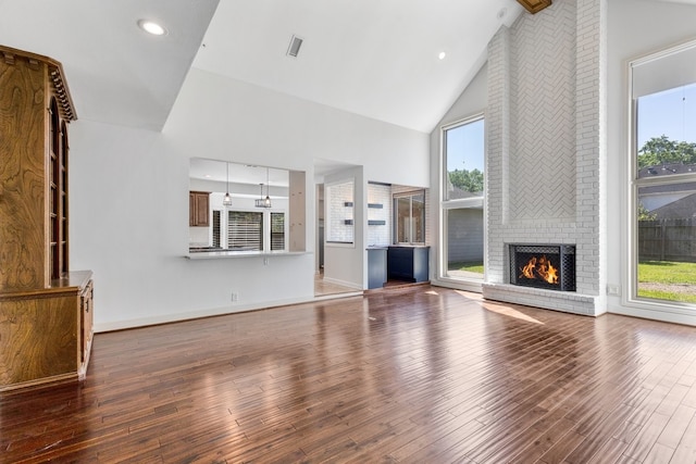 12151 Maple Rock Dr, Houston, TX 77077 - unfurnished living room featuring high vaulted ceiling, wood-type flooring, healthy amount of natural light, and a brick fireplace