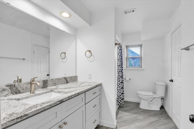 12151 Maple Rock Dr, Houston, TX 77077 - bathroom featuring toilet, vanity, baseboards, wood tiled floors, and a shower with curtain
