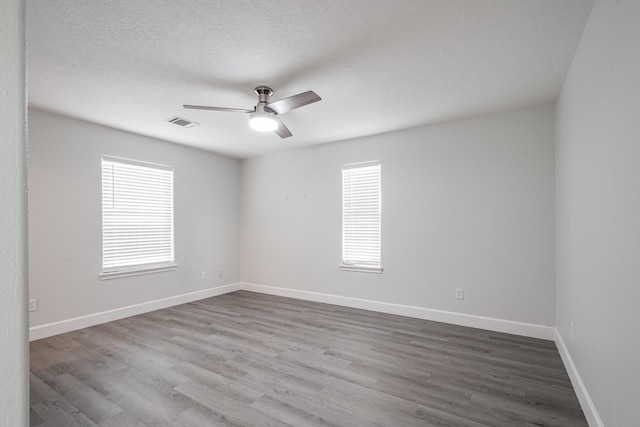 9026 Mcgallion Rd, Houston, TX 77022 - empty room featuring a ceiling fan, wood finished floors, a textured ceiling, and baseboards