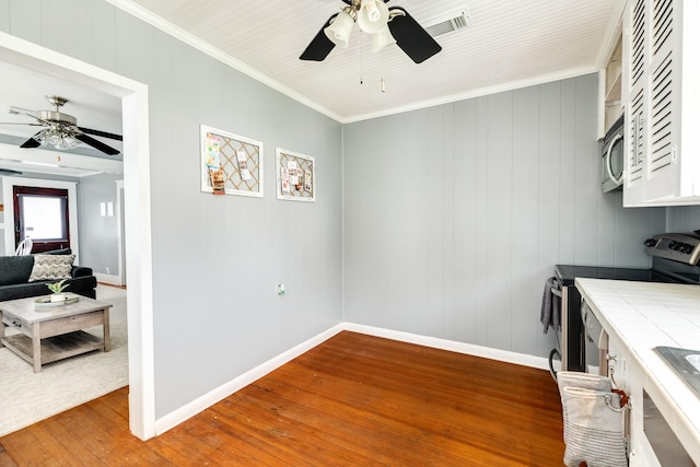 711 17th St, Galveston, TX 77550 - kitchen with tile countertops, ceiling fan, appliances with stainless steel finishes, light wood-type flooring, and ornamental molding