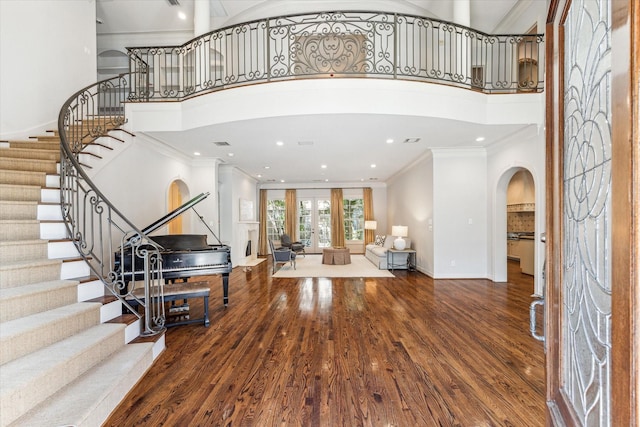 1 Exbury Way, Houston, TX 77056 - foyer featuring arched walkways, crown molding, a high ceiling, stairway, and wood finished floors