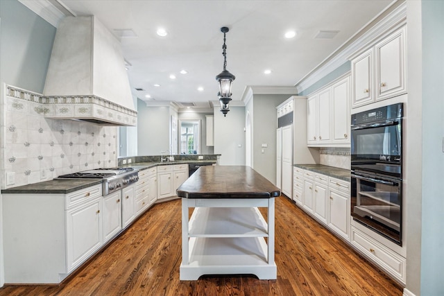 1 Exbury Way, Houston, TX 77056 - kitchen featuring black appliances, crown molding, custom exhaust hood, decorative backsplash, and dark wood-style flooring