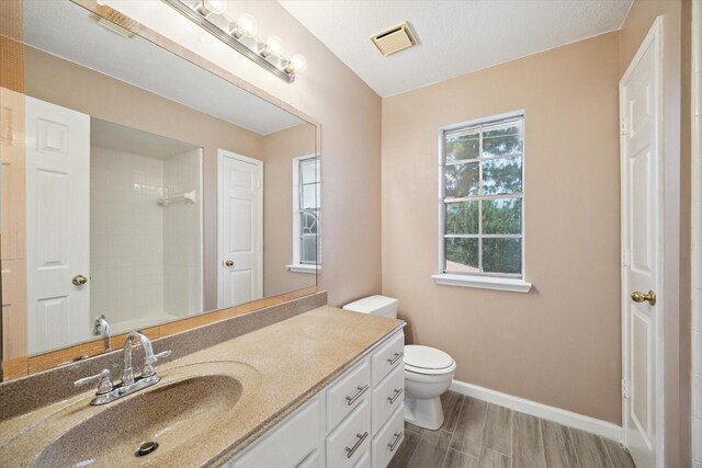 19119 Timber Trace Dr, Humble, TX 77346 - bathroom with a shower, vanity, baseboards, toilet, and wood finished floors