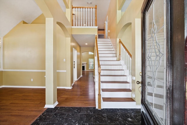 19119 Timber Trace Dr, Humble, TX 77346 - entryway featuring arched walkways, marble look tiles, stairway, baseboards, and a high ceiling