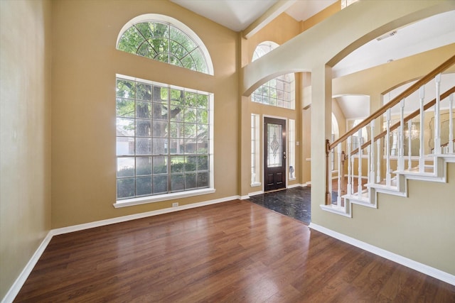 19119 Timber Trace Dr, Humble, TX 77346 - entrance foyer with arched walkways, wood finished floors, stairs, a high ceiling, and baseboards