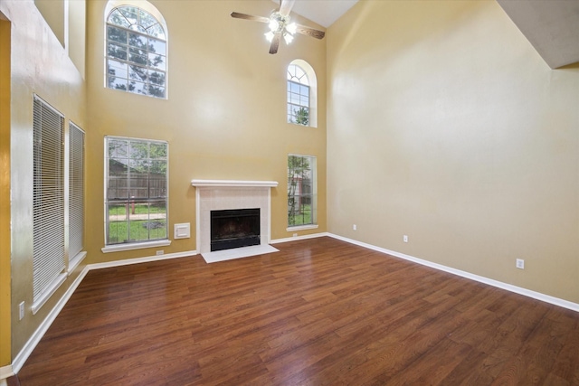 19119 Timber Trace Dr, Humble, TX 77346 - unfurnished living room with wood finished floors, a ceiling fan, high vaulted ceiling, a fireplace with flush hearth, and baseboards
