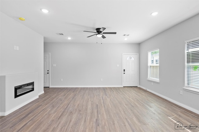 7983 Ethel St, Houston, TX 77028 - unfurnished living room with ceiling fan, recessed lighting, wood finished floors, baseboards, and a glass covered fireplace