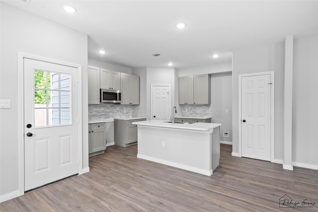 7983 Ethel St, Houston, TX 77028 - kitchen featuring stainless steel microwave, gray cabinetry, backsplash, and recessed lighting