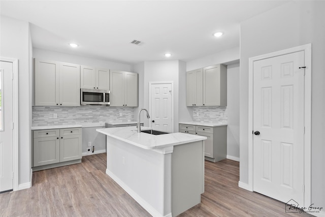 7983 Ethel St, Houston, TX 77028 - kitchen with a sink, stainless steel microwave, gray cabinets, tasteful backsplash, and recessed lighting
