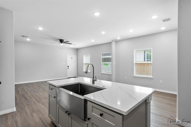 7983 Ethel St, Houston, TX 77028 - kitchen featuring a sink, gray cabinets, a ceiling fan, open floor plan, and light stone counters