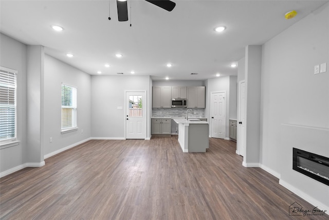 7983 Ethel St, Houston, TX 77028 - kitchen with gray cabinets, stainless steel microwave, light countertops, a ceiling fan, and open floor plan