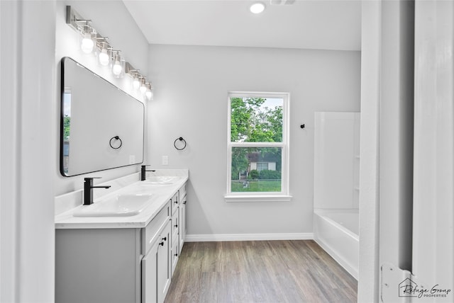 7983 Ethel St, Houston, TX 77028 - full bath with wood finished floors, double vanity, baseboards, and a bath