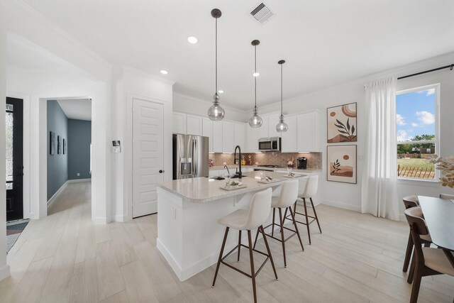 1911 Huntly Chase Dr, Houston, TX 77080 - kitchen featuring stainless steel appliances, a sink, tasteful backsplash, a kitchen island with sink, and light countertops