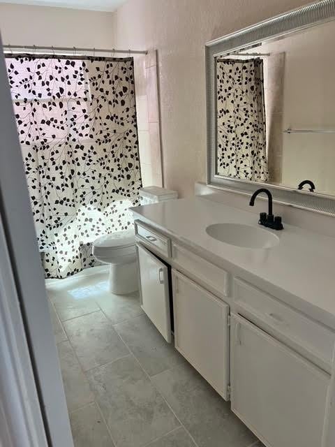 7847 Creekbend Dr, Houston, TX 77071 - full bath featuring toilet, vanity, a shower with curtain, and tile patterned floors