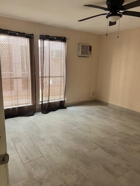 7847 Creekbend Dr, Houston, TX 77071 - unfurnished room with an AC wall unit and a ceiling fan