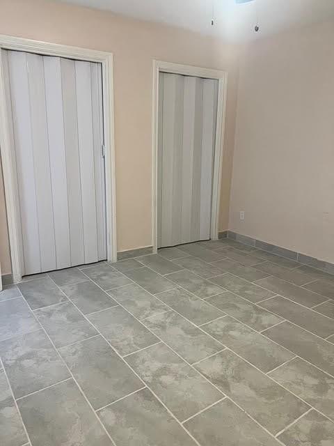 7847 Creekbend Dr, Houston, TX 77071 - unfurnished bedroom with baseboards and multiple closets