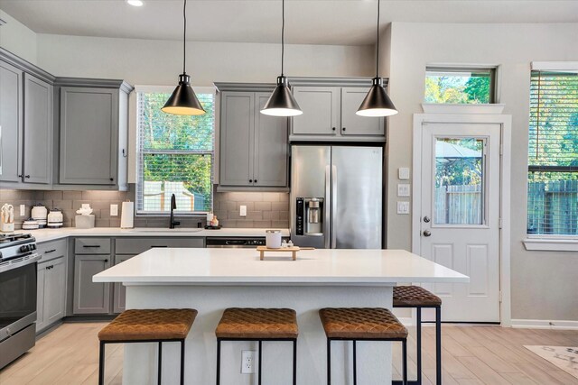 477 Long Leaf Pine Dr, Montgomery, TX 77316 - kitchen with gray cabinets, stainless steel appliances, a sink, tasteful backsplash, and light wood finished floors