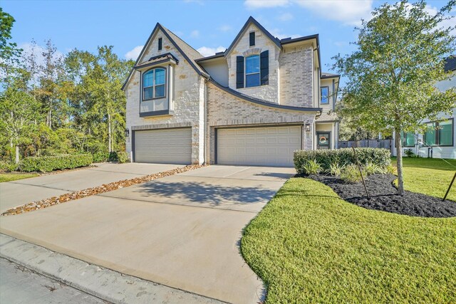477 Long Leaf Pine Dr, Montgomery, TX 77316 - view of front facade with stone siding, an attached garage, concrete driveway, and a front yard