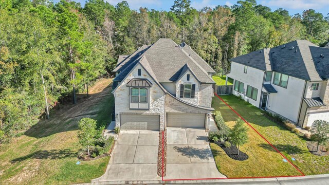 477 Long Leaf Pine Dr, Montgomery, TX 77316 - view of front of property with driveway, an attached garage, stone siding, and a front lawn