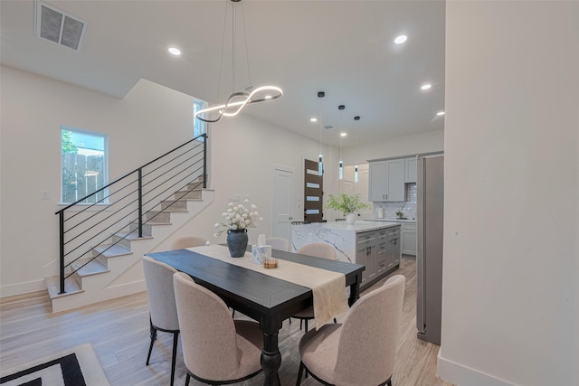2909 Nagle St, Houston, TX 77004 - dining space featuring stairs, baseboards, light wood-style flooring, recessed lighting, and a chandelier