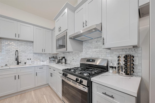 2909 Nagle St, Houston, TX 77004 - kitchen with gas stove, range hood, built in microwave, a sink, and decorative backsplash