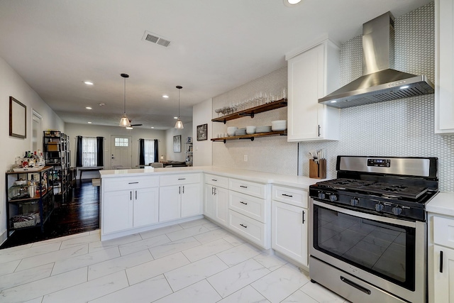 5120 Leeland St, Houston, TX 77023 - kitchen with stainless steel gas stove, wall chimney exhaust hood, open floor plan, light marble finish floors, and light countertops