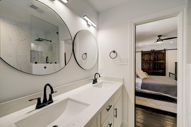 5120 Leeland St, Houston, TX 77023 - ensuite bathroom with double vanity, a marble finish shower, a ceiling fan, and hardwood / wood-style flooring