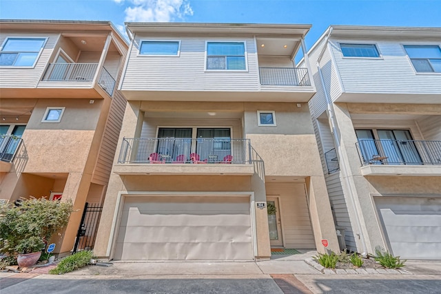 804 Paige St, Houston, TX 77003 - view of front of property with stucco siding, a garage, and a balcony