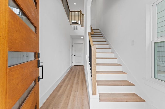 1428 Miller St, Houston, TX 77003 - stairway with wood finished floors, a towering ceiling, baseboards, and recessed lighting