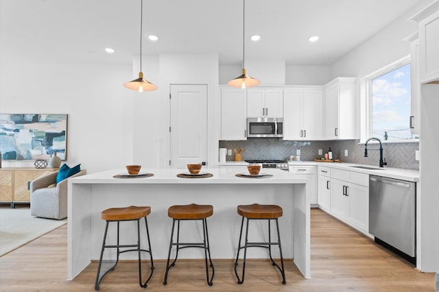 1428 Miller St, Houston, TX 77003 - kitchen featuring stainless steel appliances, a sink, a kitchen bar, decorative backsplash, and recessed lighting