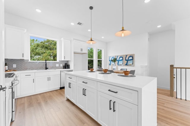 1428 Miller St, Houston, TX 77003 - kitchen with appliances with stainless steel finishes, a sink, light wood-type flooring, decorative backsplash, and light countertops
