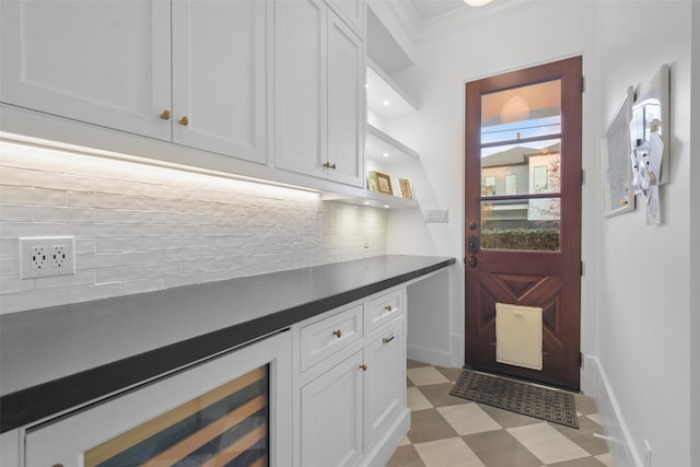 2804 Robinhood St, West University Place, TX 77005 - bar area with tasteful backsplash, ornamental molding, light flooring, wine cooler, and baseboards