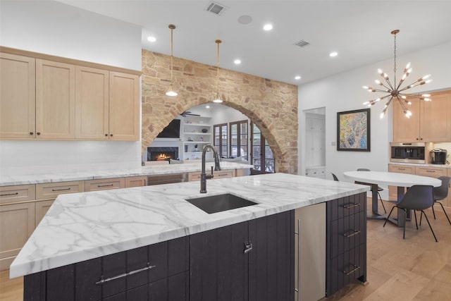 2804 Robinhood St, West University Place, TX 77005 - kitchen featuring a sink, a fireplace, light brown cabinets, light wood-type flooring, and recessed lighting