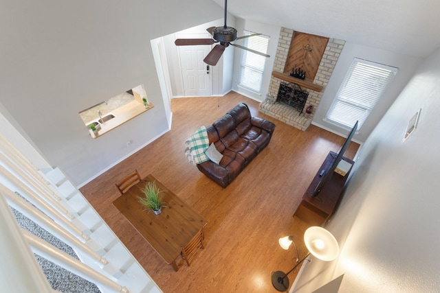 4315 Stallion Brook Ln, Spring, TX 77388 - living room with ceiling fan, a brick fireplace, wood finished floors, and baseboards
