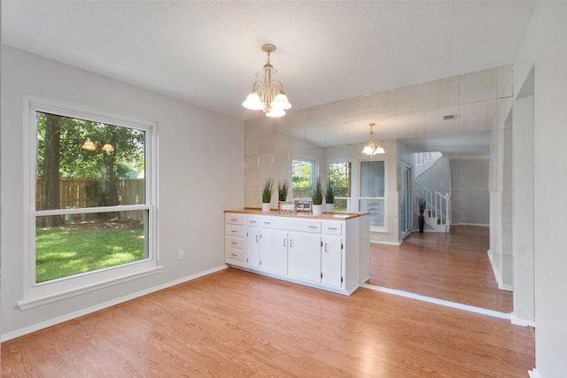 4315 Stallion Brook Ln, Spring, TX 77388 - kitchen featuring a chandelier, light wood-type flooring, white cabinetry, pendant lighting, and light countertops