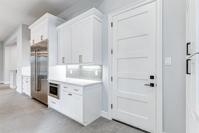 9606 Maribelle Way, Houston, TX 77055 - kitchen featuring high end fridge, light countertops, white cabinetry, and baseboards