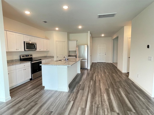 21650 Cottage Ln, New Caney, TX 77357 - kitchen with stainless steel appliances, a sink, dark wood-style floors, white cabinets, and recessed lighting
