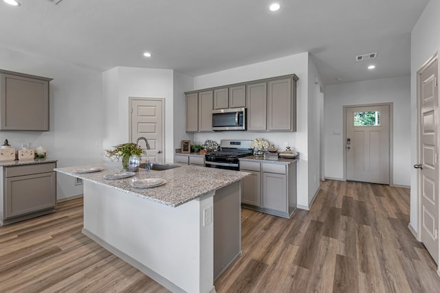 6545 Alexis St, Beaumont, TX 77708 - kitchen featuring stainless steel appliances, gray cabinets, a sink, wood finished floors, and recessed lighting