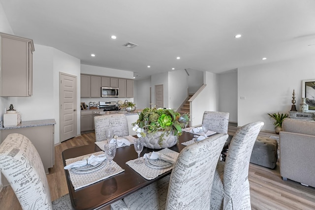 6545 Alexis St, Beaumont, TX 77708 - dining space with light wood-type flooring, stairs, and recessed lighting