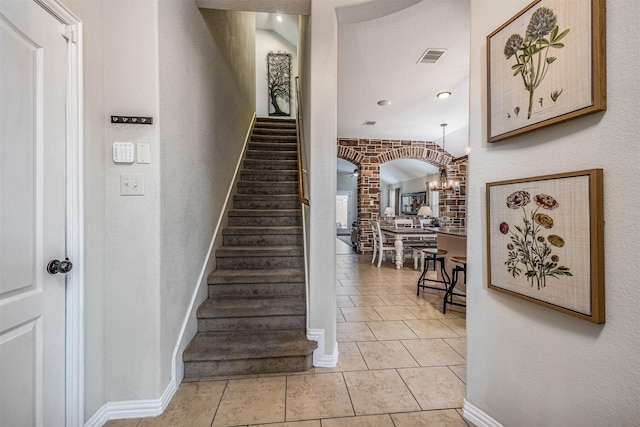 4818 Connor Dr, Baytown, TX 77521 - staircase featuring arched walkways, tile patterned floors, baseboards, and a chandelier