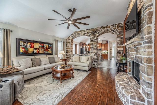 4818 Connor Dr, Baytown, TX 77521 - living area featuring arched walkways, a ceiling fan, dark wood-style floors, a fireplace, and vaulted ceiling