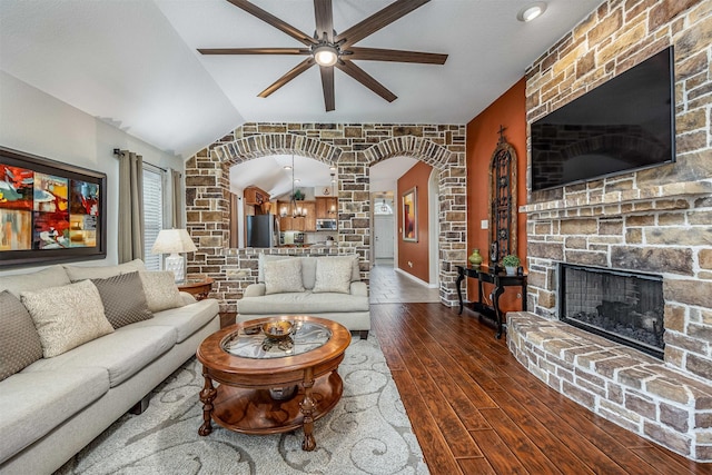 4818 Connor Dr, Baytown, TX 77521 - living area featuring ceiling fan, a fireplace, arched walkways, dark wood-type flooring, and vaulted ceiling