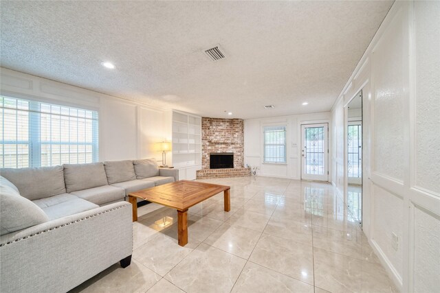 7838 Vickijohn Dr, Houston, TX 77071 - living room featuring a textured ceiling, a fireplace, a decorative wall, recessed lighting, and light tile patterned floors