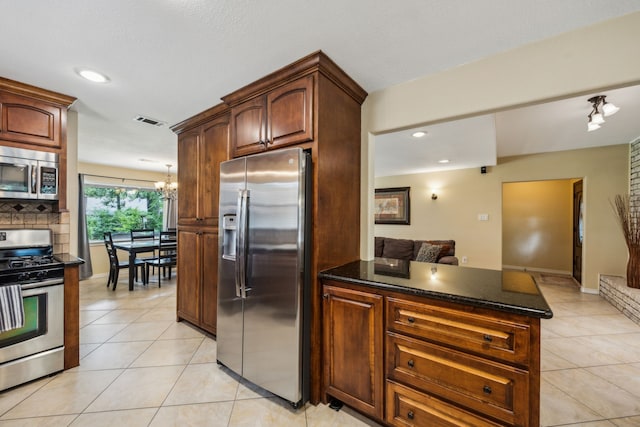 233 Magnolia Way, Huntsville, TX 77320 - kitchen with appliances with stainless steel finishes, light tile patterned flooring, recessed lighting, dark stone counters, and a chandelier