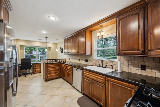 233 Magnolia Way, Huntsville, TX 77320 - kitchen with stainless steel appliances, a sink, a peninsula, dark countertops, and decorative light fixtures